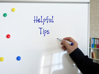 Financial concept meaning Helpful Tips with inscription on the piece of paper.