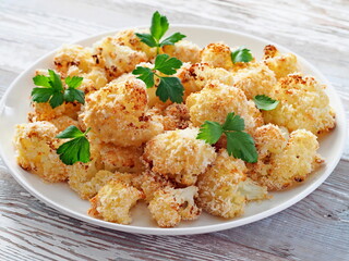Cauliflower baked in breadcrumbs decorated with celery leaves.