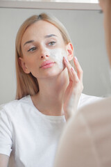 
Girl in the morning washes her face with foam