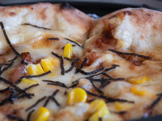 海苔とコーンとチーズの美味しいピザのクローズアップ。