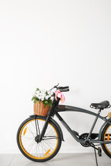 Modern bicycle with basket near white wall