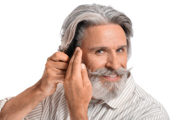 Mature man combing hair on white background