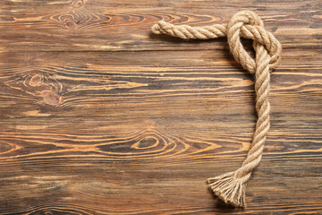 Obraz premium Rope with knot on wooden background