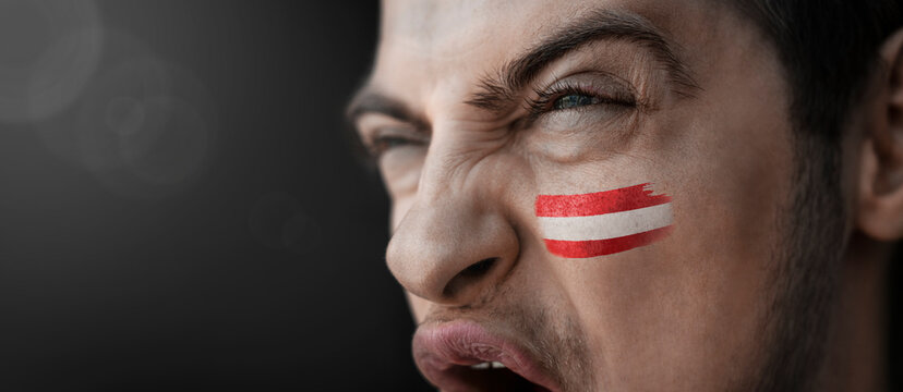 A screaming man with the image of the country's national flag on his face - Powered by Adobe