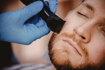 Barber with blue medical gloves protection coronavirus shearing beard to man in barbershop