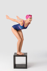 Female swimmer on light background