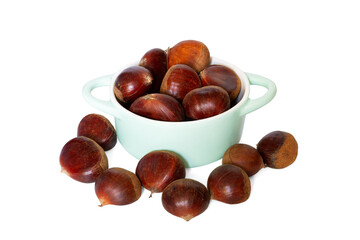 A pile of fresh chestnuts inside and outside double handle greenish porcelain bowl isolated on the white background. Close-up and macro. Focus stacking.