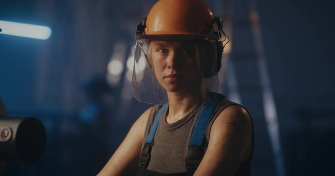 Professional woman in hardhat on factory production