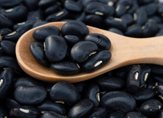 Black beans in wooden spoon.