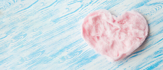Pink delicious heart made of sweet cotton candy on blue background. Trendy minimal art style, banner