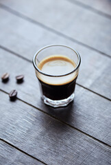 Coffee in glass cup on rustic wooden background. Close up.