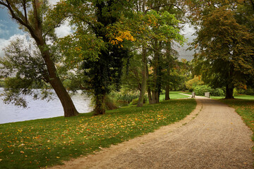 Weg mit Bäumen im Park des ehemaligen Jagdschlosses Glienicke am Ufer der Glienicker Lake in Berlin-Wannsee