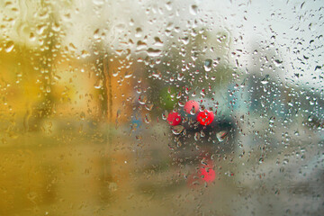 View from the inside of the car during the rain on the city street in defocus