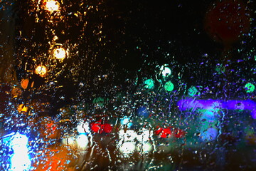 Fototapeta na wymiar Rainy street at night, with beautiful blurred colors