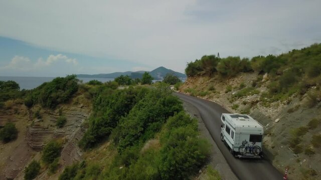 Aerial view of motorhome travelling on road with sea  background in Montenegro
