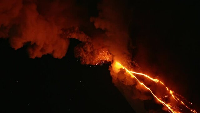 Vertical video. Smoke and burning lava erupting from vent. Night timelapse of Klyuchevskaya Sopka or Klyuchevskoy volcano eruption on Kamchatka. Stars moving on sky. Concept of wild nature and geology