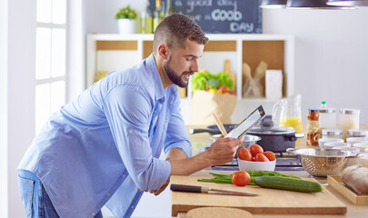 Smiling and confident chef standing in large kitchen