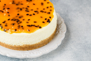 Passion fruit cheesecake on a white plate on a gray concrete background. Delicious homemade cake. Selective focus, copy space - 399932998