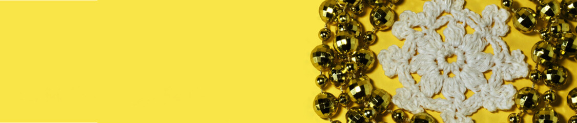 Banner yellow with beads around knitted snowflakes with copy space. High quality photo