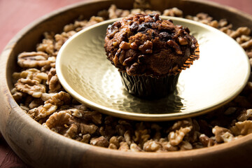 Walnuss Muffin in gold Messing Metall und Holz Schale mit Nüsse auf Holz Tisch Hintergrund