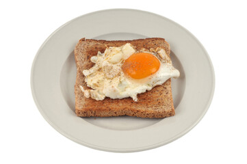 Oeuf au plat sur une tranche de pain de mie dans une assiette en gros plan sur fond blanc