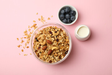 Concept of tasty breakfast with granola on pink background