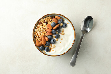 Bowl of granola and spoon on white background