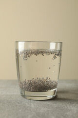 Glass with chia and water on gray table