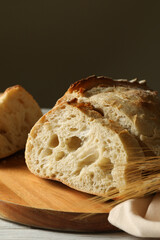 Board with fresh bread on white wooden background