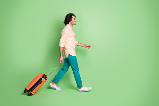 Full Length Body Size Profile Side View Of Cheerful Guy Departing Carrying Bag Voyage Bus Station Isolated Over Bright Green Color Background