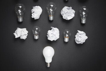 Light bulbs and crumpled papers on the black background. Idea