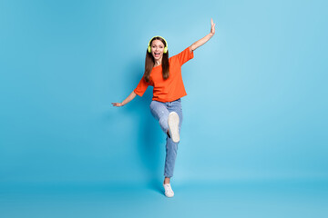 Fototapeta na wymiar Photo of cheerful woman wearing casual red t-shirt dancing one leg listening favorite song isolated blue color background