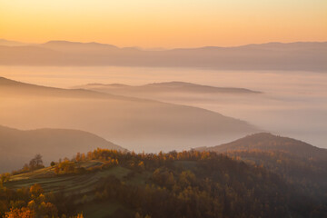 Landscape of mountains at sunrise in the fog. Beautiful background.