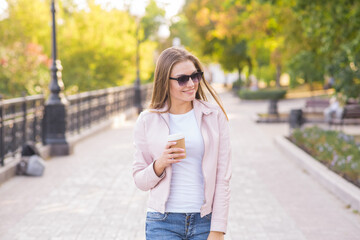 Portrait of a young, happy and pretty blonde girl with a cup of coffee in her hands