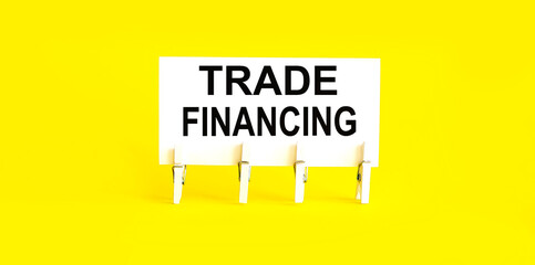 text TRADE FINANCING on the white short note paper yellow background
