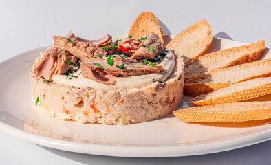 plate with a typical spanish ensaladilla rusa, russian salad with tuna, caviar and roasted bread