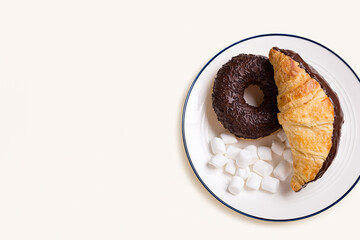 Croissant and donut on a round plate