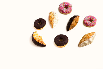 Fototapeta na wymiar Croissants and donuts on a light background