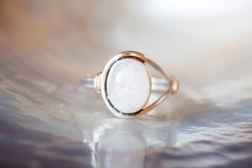 Silver ring with moon stone gemstone on pearl white background