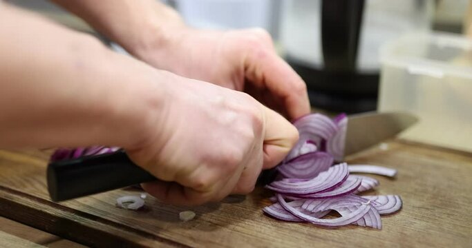 Man chopping onions with kitchen knife on wood board 4k movie. Vegetable recipe concept