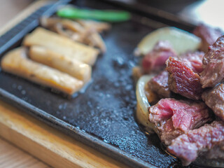 Japanese teppanyaki fried beef on hot plate with vegetabl