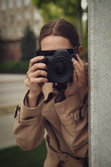 Private detective with modern camera spying on city street