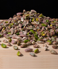 pistachios on wood and black background