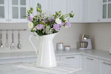 Fototapeta na wymiar Beautiful bouquet with Eustoma flowers on table in kitchen