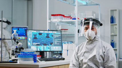 Close up of tired chemist man doctor in coverall working in scientific equipped laboratory....