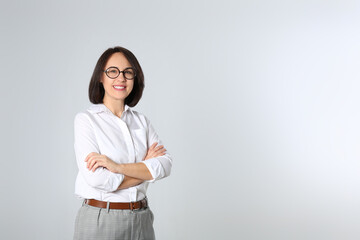 Portrait of mature businesswoman on light grey background. Space for text