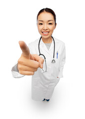 Fototapeta premium medicine, profession and healthcare concept - happy smiling asian female doctor with stethoscope in white coat pointing to camera