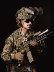 Delta Force soldier, US army special forces. Combat application group, Army compartmented element operator - Tier 1. Portrait on a black backdrop with rifle and night vision.