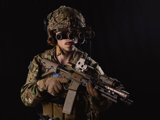 Delta Force soldier, US army special forces. Combat application group, Army compartmented element operator - Tier 1. Portrait on a black backdrop with rifle and night vision.