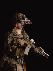 Delta Force soldier, US army special forces. Combat application group, Army compartmented element operator - Tier 1. Portrait on a black backdrop with rifle and night vision.